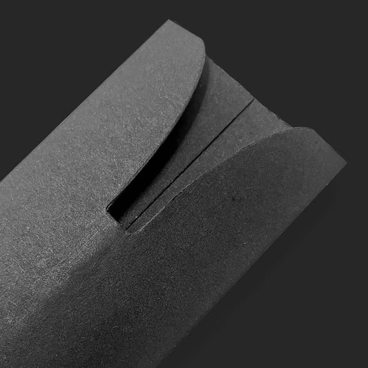 Nahaufnahme des Etuis aus Pappe, elegant präsentiert auf dunklem Fotohintergrund.