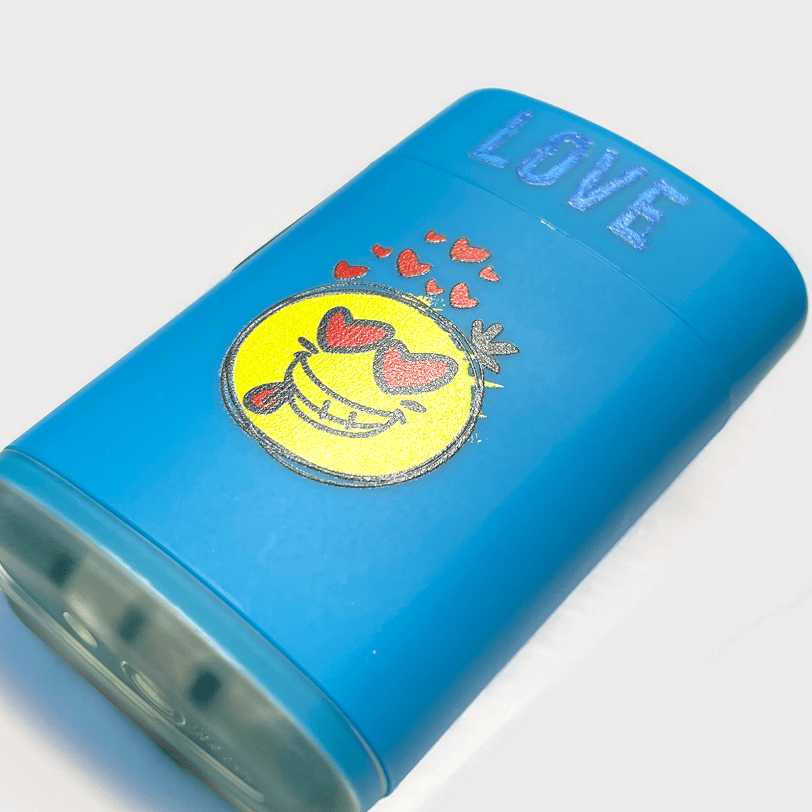 Blaues Sturmfeuerzeug mit Emoji Druck auf einem Tisch