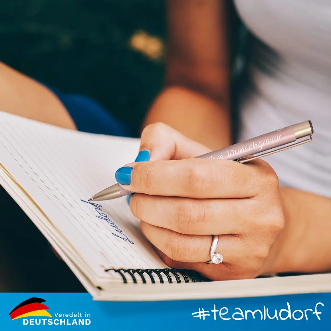 Frau schreibt mit GLORI Kugelschreiber im Notizbuch