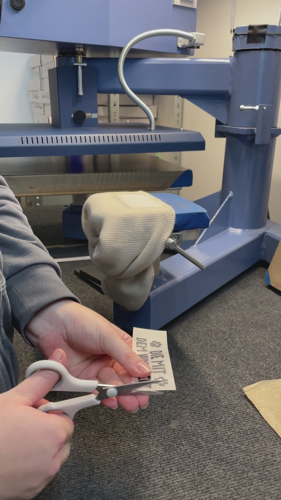 Video zeigt den Druckprozess von Wintermützen mit den lustigen Hundemotiven „Der mit dem Hund geht“ und „Die mit dem Hund geht“. Sehen Sie, wie die Mützen Schritt für Schritt personalisiert werden – ideal für Geschenkideen und Hundeliebhaber.